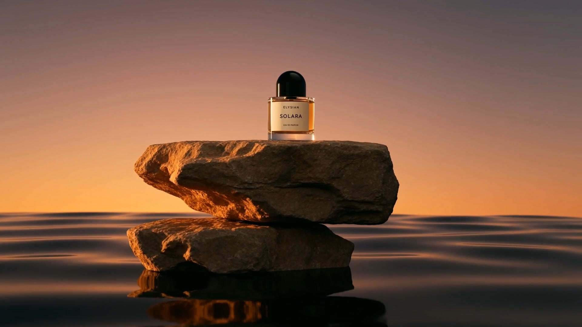 A perfume bottle on stacked stone above still water at sunset